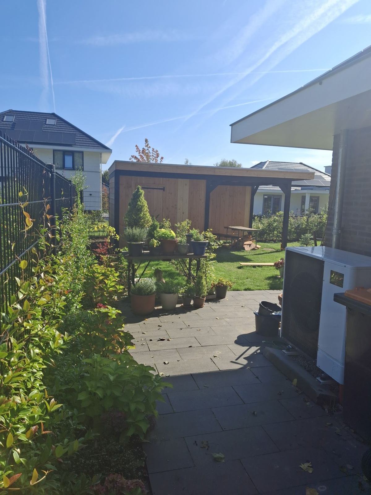 Tuin met achterin een donkere overkapping